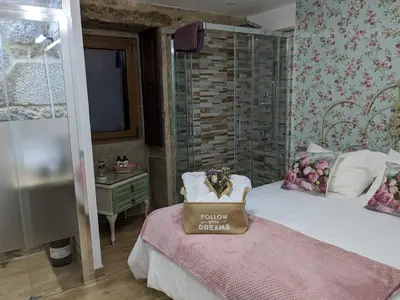 a bedroom with a bed with a bag on it at El cobijo de Soar ¡Casa rural completa! in Moraña