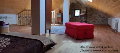 a bedroom with a bed and a red ottoman at El cobijo de Soar ¡Casa rural completa! in Moraña
