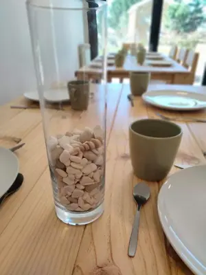 a glass vase filled with rocks on a wooden table at Anam Cara House in Serantes