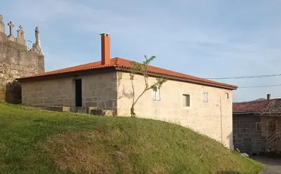 a small stone building with a red roof on a hill at O Noso Lar - RIBEIRA SACRA in Nogueira de Ramuin