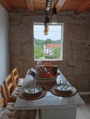a table with a basket of food and a window at O Noso Lar - RIBEIRA SACRA in Nogueira de Ramuin