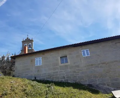 a building with a clock tower on top of it at O Noso Lar - RIBEIRA SACRA in Nogueira de Ramuin
