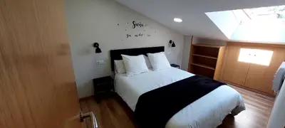a bedroom with a bed with white sheets and a window at Casa Tarrazo II in Monforte de Lemos
