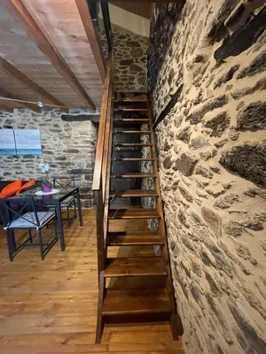 a wooden staircase leading up to a stone wall at Apartamento Felicitas en La Casa de Cobos, Ribeira Sacra in Puebla del Brollón