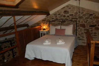 a bedroom with a bed with two towels on it at Apartamento Felicitas en La Casa de Cobos, Ribeira Sacra in Puebla del Brollón