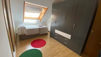 a small bedroom with a bed and a red rug at A CUARTA RONDA in Melide