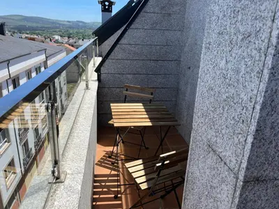a wooden bench sitting on the side of a building at A CUARTA RONDA in Melide
