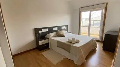a bedroom with a bed and a large window at A CUARTA RONDA in Melide