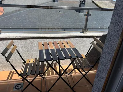 a wooden chair sitting on top of a balcony at A CUARTA RONDA in Melide