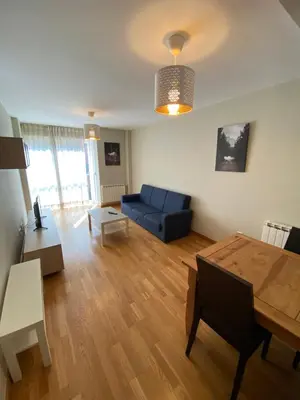 a living room with a blue couch and a table at dpCristal Calvo Sotelo 164, 4C in Sarria