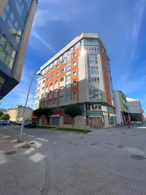 a tall building in a city with a parking lot at dpCristal Calvo Sotelo 164, 4C in Sarria