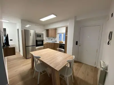 a kitchen and dining room with a wooden table and chairs at Vivienda Alameda de Santiago in Santiago de Compostela