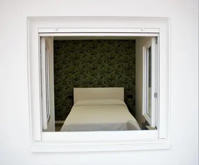a bed is seen through an open window at Vivienda Alameda de Santiago in Santiago de Compostela