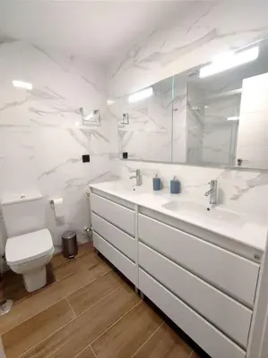 a white bathroom with two sinks and a toilet at Vivienda Alameda de Santiago in Santiago de Compostela