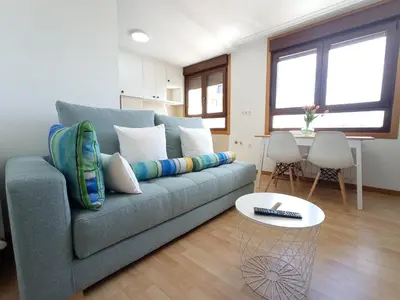 a living room with a blue couch and a table at Apartamento Alfa in Monforte de Lemos