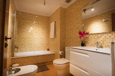 a bathroom with a toilet and a sink and a tub at dpCristal Ático Vistas al Camino in Sarria