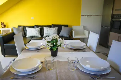a dining room table with plates and flowers on it at dpCristal Ático Vistas al Camino in Sarria