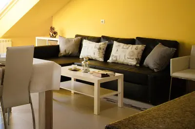 a living room with a black couch and a table at dpCristal Ático Vistas al Camino in Sarria