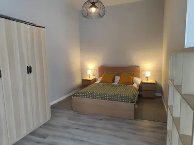 a bedroom with a bed and two lamps and a closet at Lar de Yago - Apto Barreiros A in Barreiros