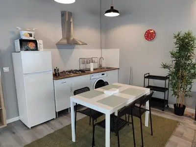 a kitchen with a table and a white refrigerator at Lar de Yago - Apto Barreiros A in Barreiros