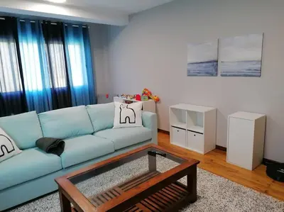 a living room with a blue couch and a coffee table at Lar de Yago - Casa in Barreiros