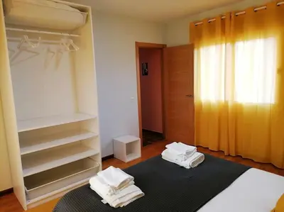a bedroom with two white towels sitting on a bed at Lar de Yago - Casa in Barreiros