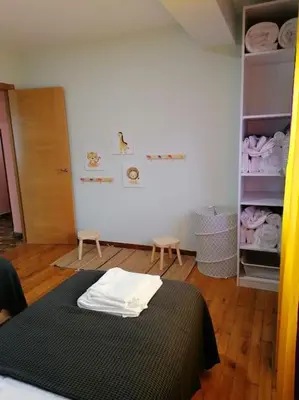 a room with a bed and a closet with towels at Lar de Yago - Casa in Barreiros