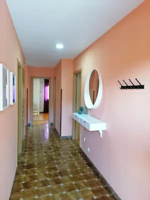 a hallway with orange walls and a mirror and a tile floor at Lar de Yago - Casa in Barreiros