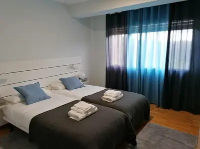a bedroom with two beds with towels on them at Lar de Yago - Casa in Barreiros
