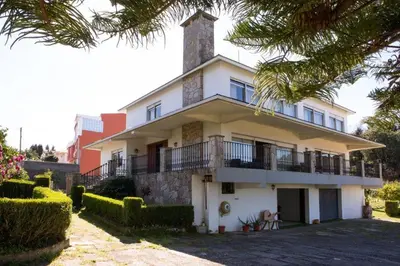a white house with a tower on top of it at Playa Miño Sombreu in Miño