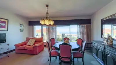 a dining room with a table and chairs and a couch at Playa Miño Sombreu in Miño
