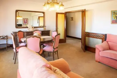 a living room with a table and chairs and a mirror at Playa Miño Sombreu in Miño