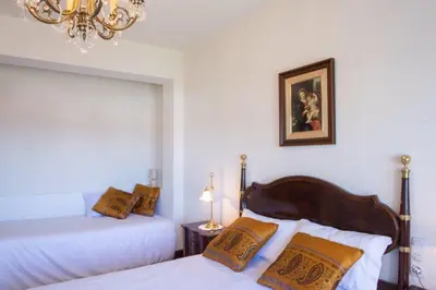 a bedroom with two beds and a chandelier at Playa Miño Sombreu in Miño