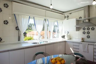 a kitchen with a table with a bowl of fruit on it at Playa Miño Sombreu in Miño