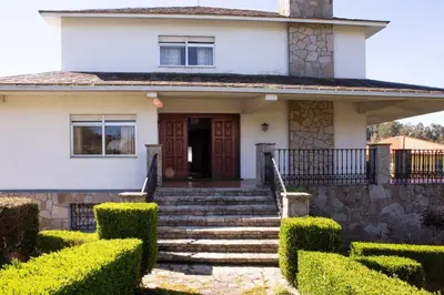 a white house with stairs and a door at Playa Miño Sombreu in Miño