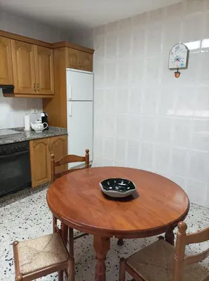 a kitchen with a wooden table and a white refrigerator at Dona Branca in Quiroga