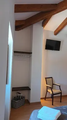 a bedroom with a bed and a chair and a tv at Hostal A Cantina de Renche in Renche
