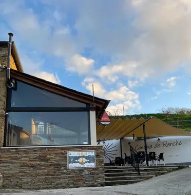 a restaurant with a large window on the side of a building at Hostal A Cantina de Renche in Renche