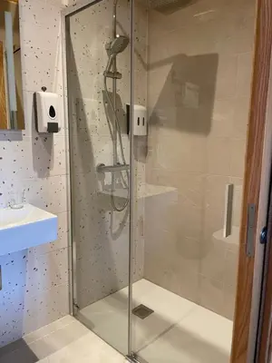 a shower with a glass door in a bathroom at Hostal A Cantina de Renche in Renche