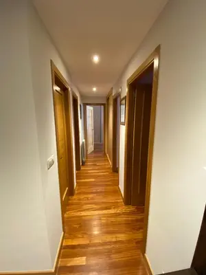a hallway in a house with wooden floors and doors at dpCristal LikeHome in Sarria
