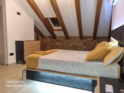 a bedroom with a bed and a brick wall at Casa Grilo in Monforte de Lemos