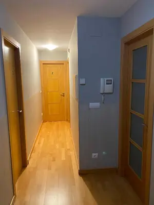an empty hallway with a yellow door and a wooden floor at Pensión Abeledo in Sarria