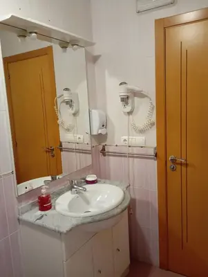 a bathroom with a sink and a mirror at Pensión Abeledo in Sarria