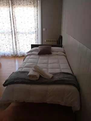 a bed with a towel on it in a bedroom at Pensión Abeledo in Sarria