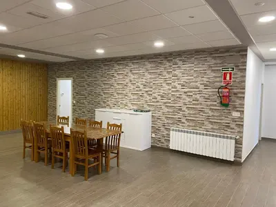 a dining room with a table and chairs and a brick wall at dpCristal El Rinconcito in Sarria