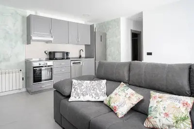 a living room with a couch and a kitchen at Alojamiento Barco de Valdeorras in Vegamolinos