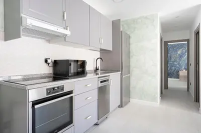 a kitchen with white cabinets and a black microwave at Alojamiento Barco de Valdeorras in Vegamolinos