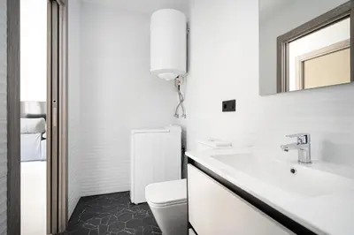 a bathroom with a sink and a toilet and a mirror at Alojamiento Barco de Valdeorras in Vegamolinos