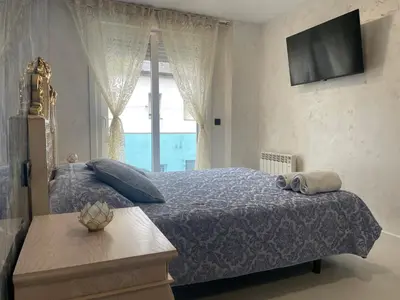 a bedroom with a bed with a tv and a window at Alojamiento Barco de Valdeorras in Vegamolinos