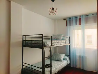 two bunk beds in a room with a window at Boa Vista Cerca del centro 2 hab y parking in Monforte de Lemos